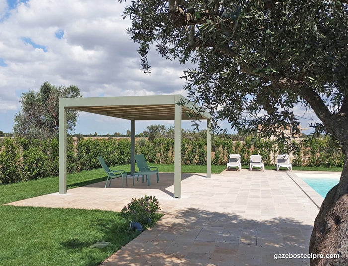 Pergola QBox Linea verde salvia in giardino, con un ulivo davanti e la piscina a destra