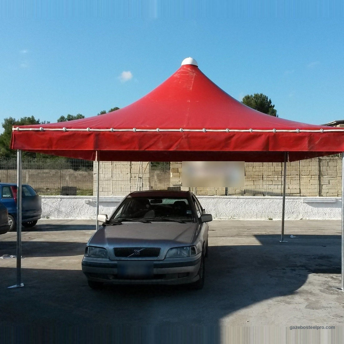 Gazebo Airone Basic con il telo rosso montato su un piazzale, foto vera