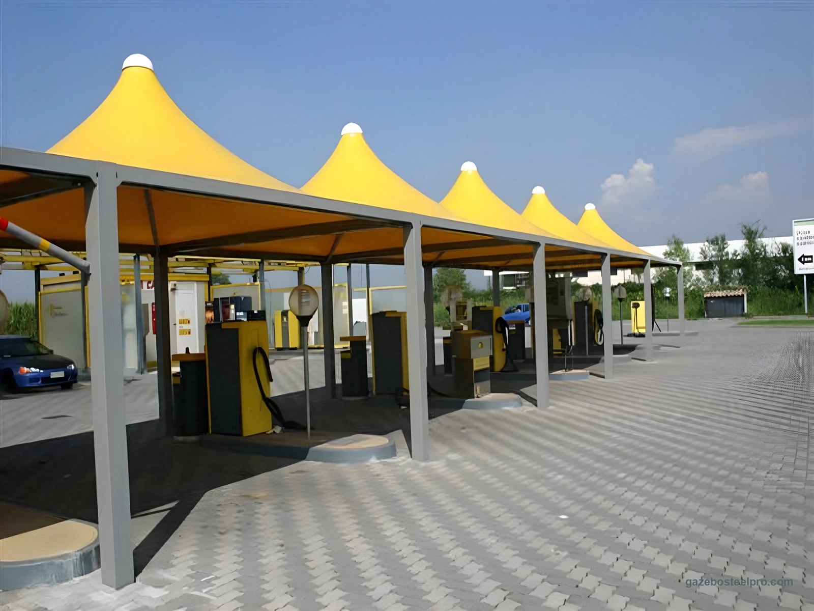 Gazebo Airone Max Leggero con telo giallo montati in fila, uno accanto all'altro, in un autolavaggio, foto vera