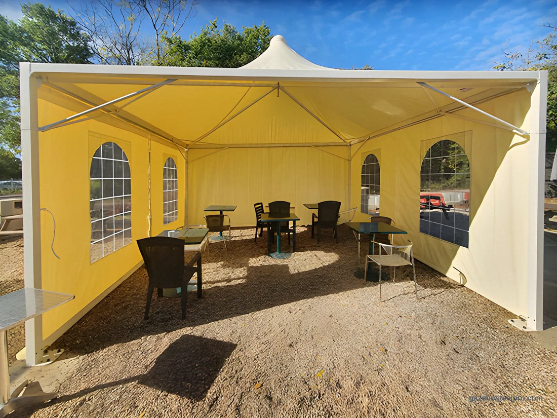 Gazebo Airone Minimax bianco chiuso su tre lati con laterali crema e finestre ad arco, tavoli su ghiaia, foto vera