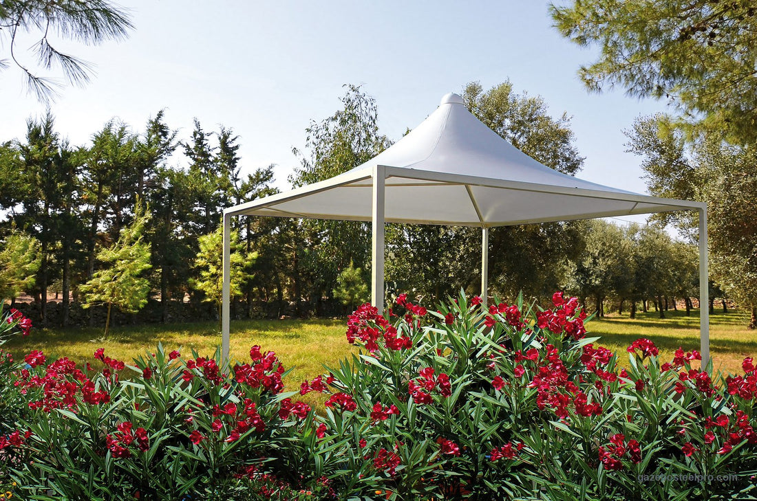 Gazebo Airone Minimax bianco in un giardino con oleandri